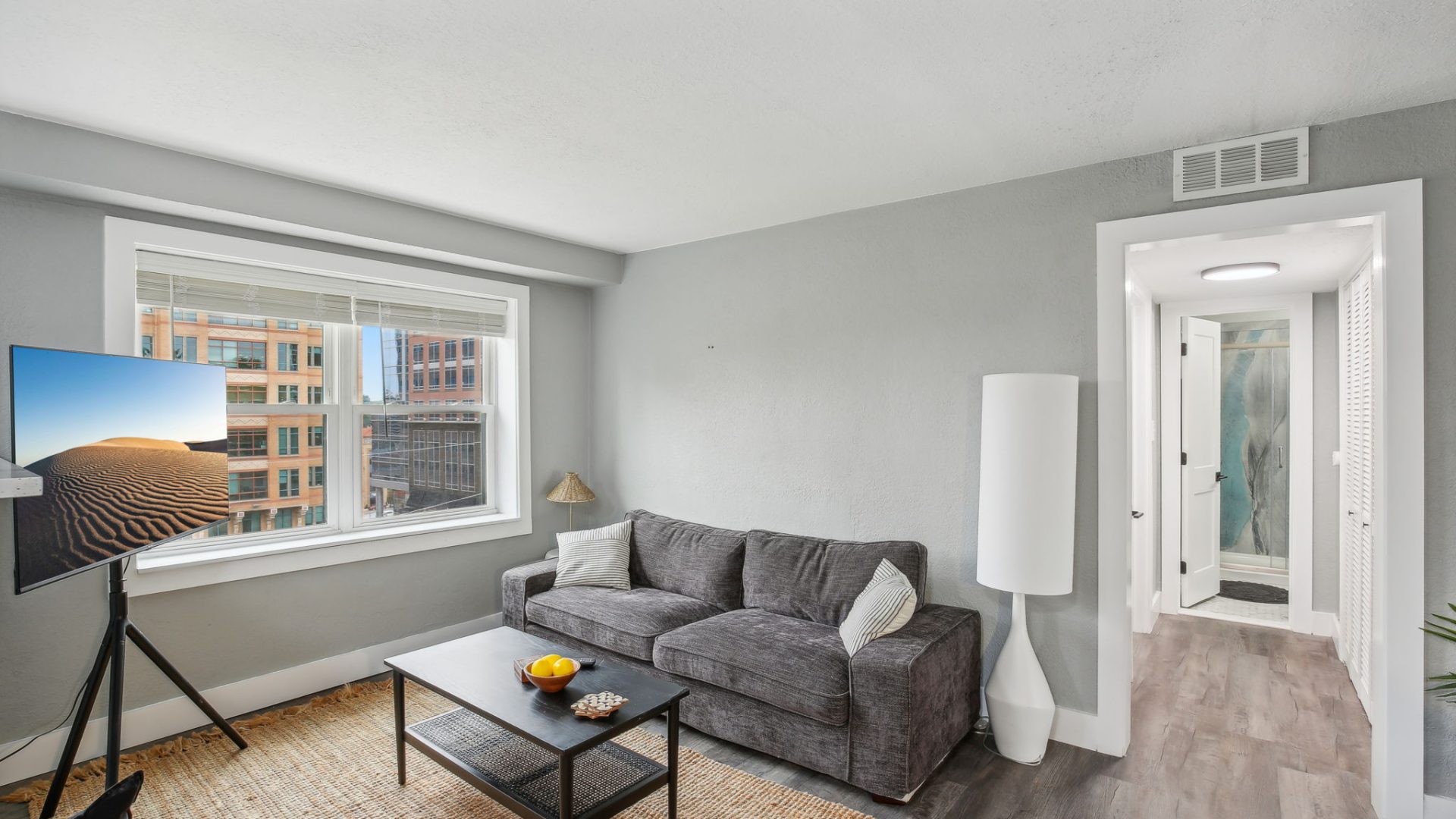 a living room with a couch, coffee table and television at The Broadway 46 Apartments